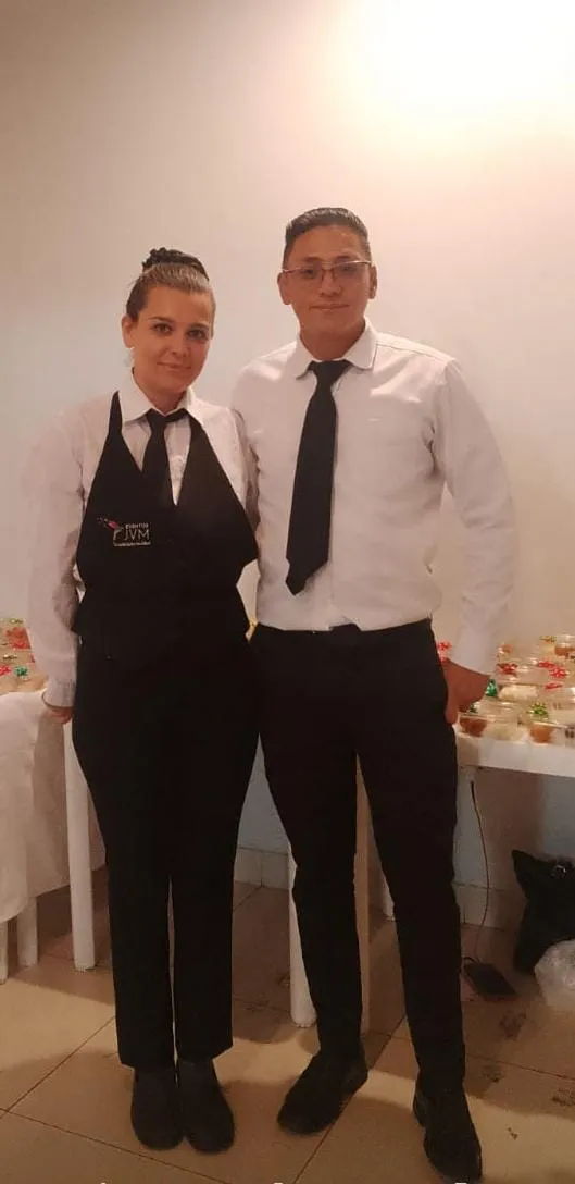 Meseros profesionales de ORS Eventos sirviendo en una fiesta corporativa elegante en Colombia, simbolizando un servicio de meseros para fiestas de alta calidad.